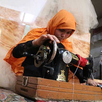 Photo of Somaya sewing on a sewing machine